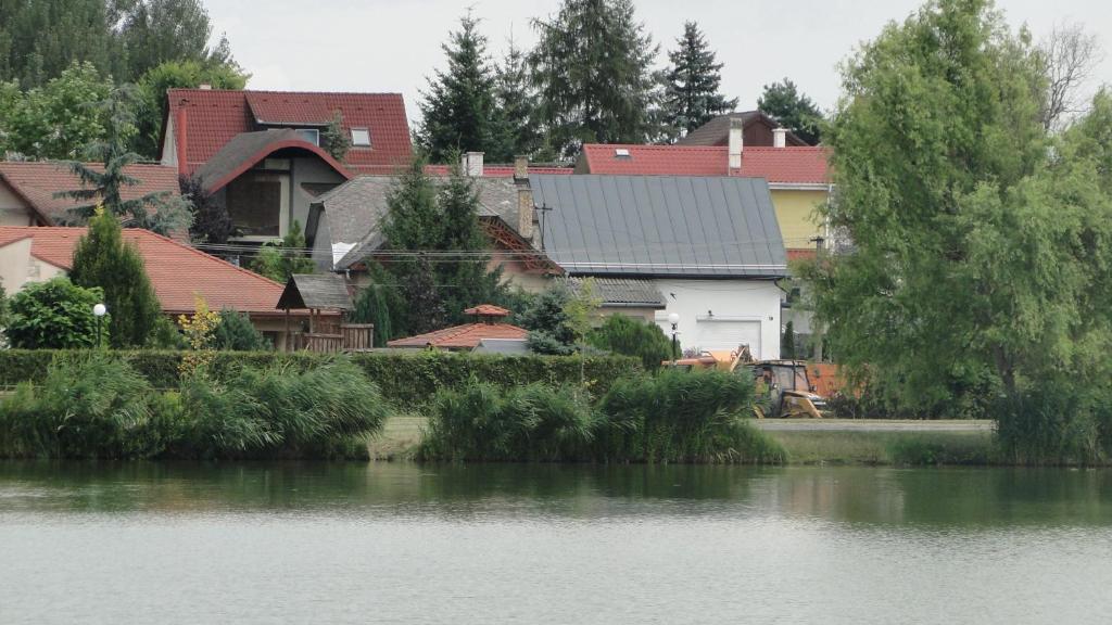 a group of houses next to a body of water at LazaApartman in Nyíregyháza
