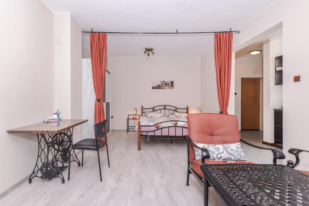 un soggiorno con letto, tavolo e sedie di Visit Sofia | Macedonia Square Central Apartment a Sofia