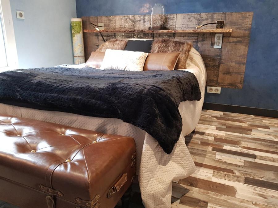 um quarto com uma cama e uma mala de couro em l'Ecrin de Vert em Saint-Alban-du-Rhône