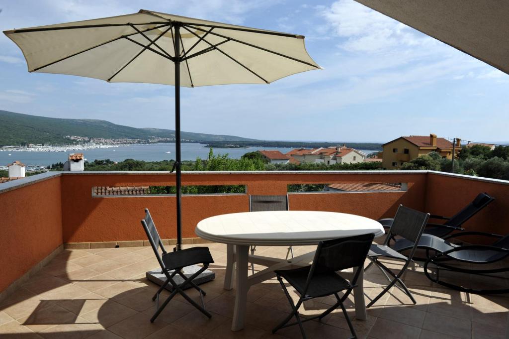 a patio with a table and chairs and an umbrella at Apartman Branka in Kornić