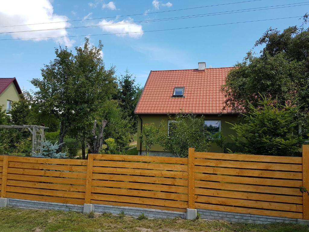 a wooden fence in front of a house at Oliwkowe Jerzykowo -klimatyzacja in Radzieje