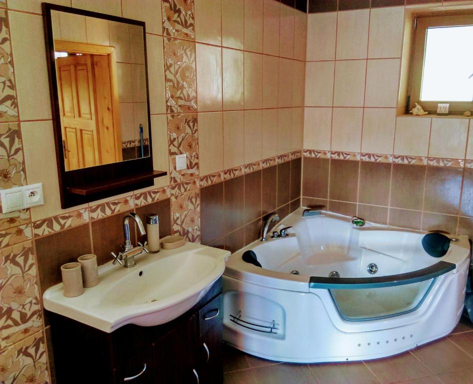 a bathroom with a tub and a sink at Apartman pod Kalváriou - rodinný dom in Banská Štiavnica