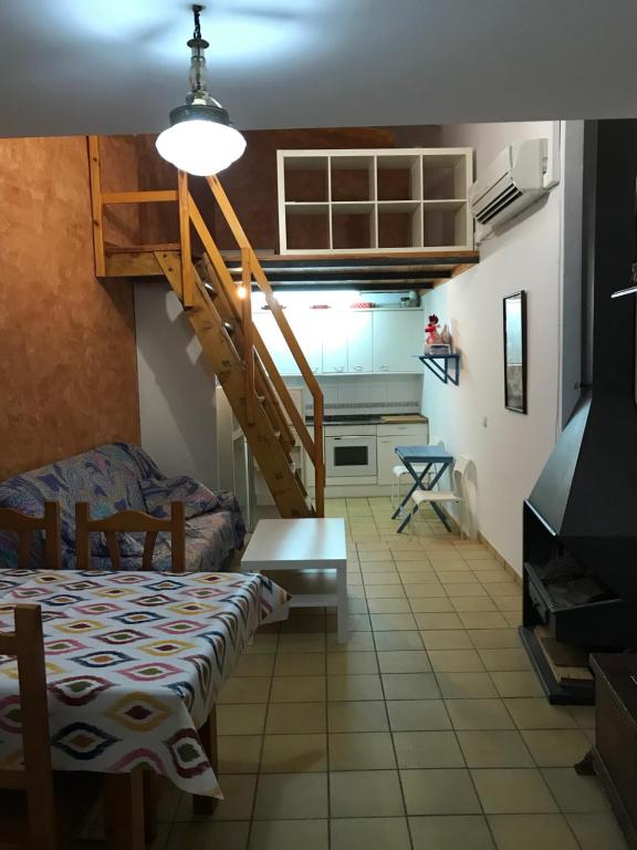 eine Küche und ein Wohnzimmer mit einem Tisch und einer Treppe in der Unterkunft Apartament Cala Magda Sant Llorenç de Montgai in Sant Llorenç de Montgai