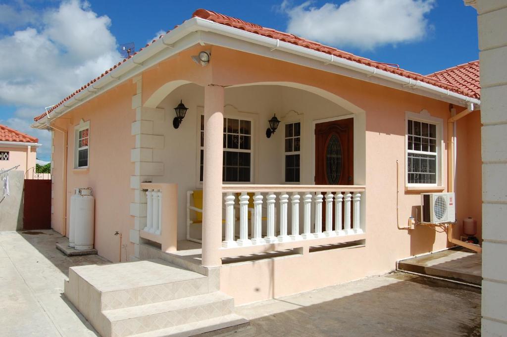 a house with a porch and a balcony at Plover Court Apartments in Christ Church