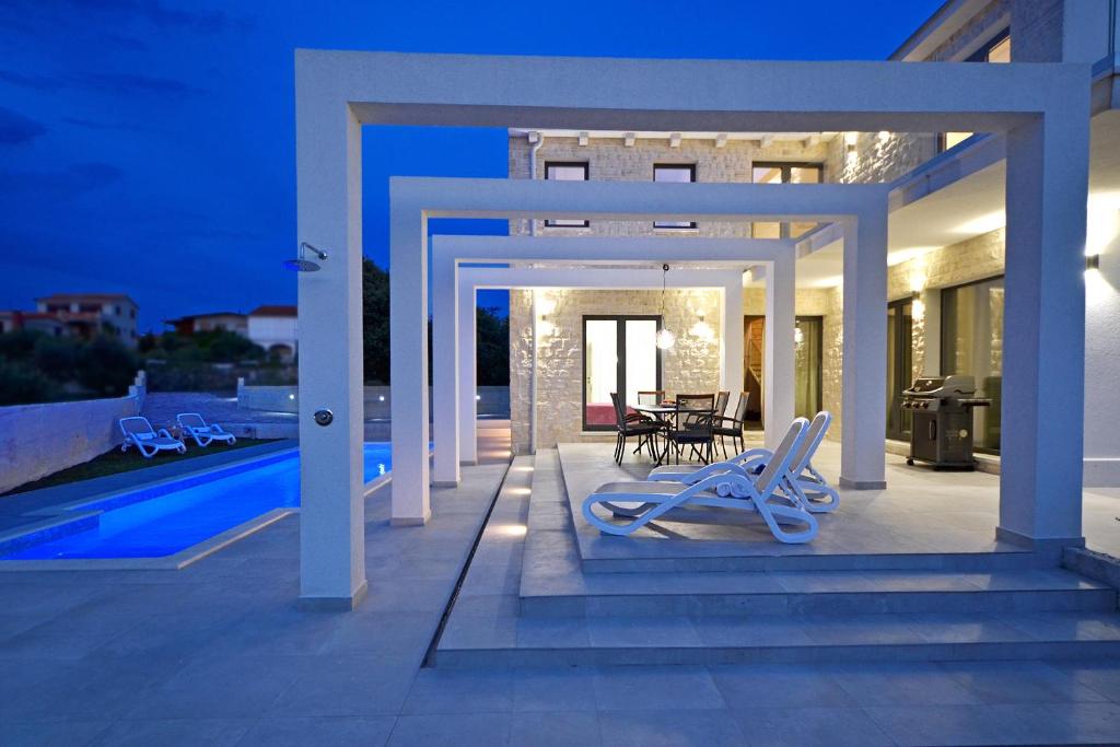 a patio with chairs and a table and a pool at Villa VI in Sevid