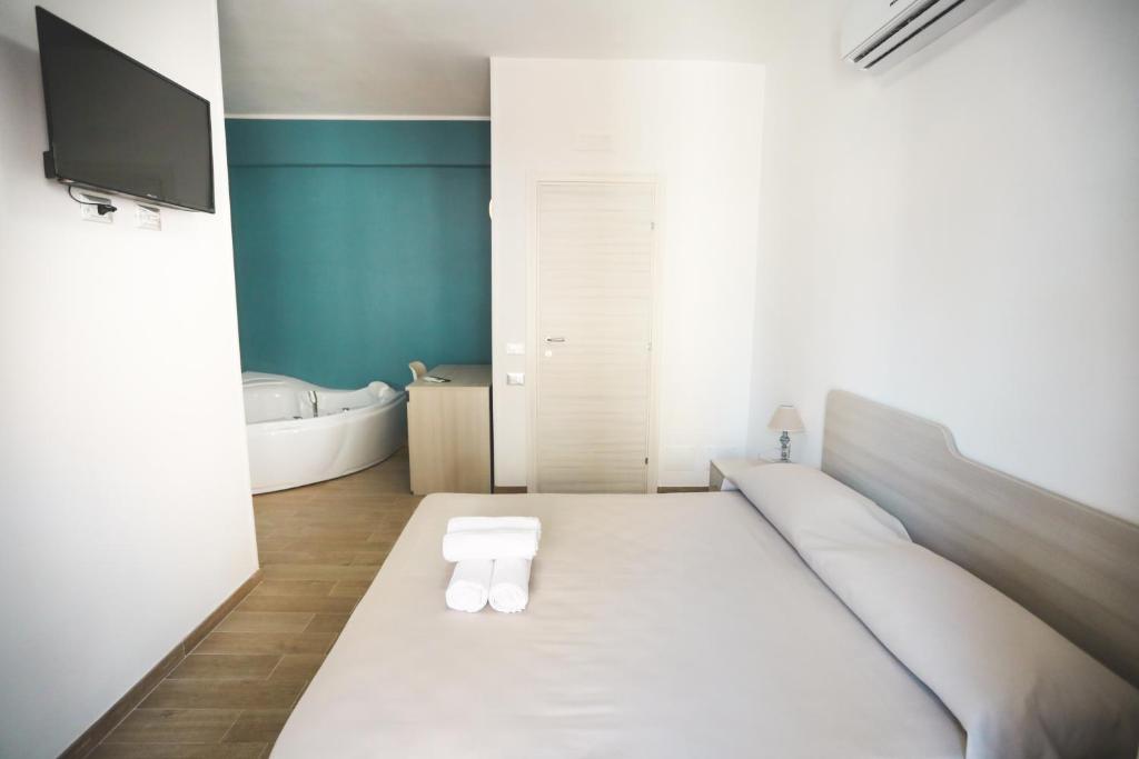 baño con cama blanca grande y bañera en Il Viaggiatore Via Rimini Serapo, en Gaeta