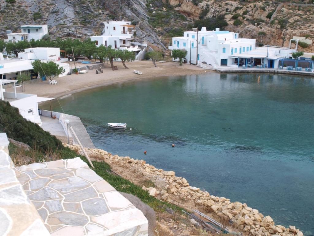 a beach with white buildings and a body of water at Kokagia House in Cherronisos