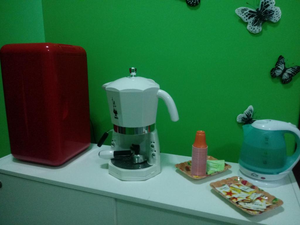 um balcão de cozinha com uma batedeira e borboletas numa parede verde em La Corte dei Morra em Venafro