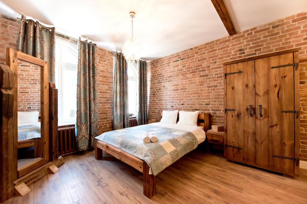 a bedroom with a brick wall and a bed at Apartament Starówka no1, no2, no3 in Toruń