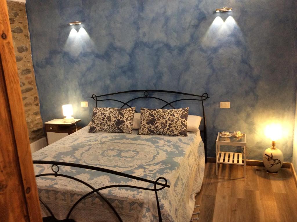 una camera con un letto e due luci sul muro di casamariu a Lucca