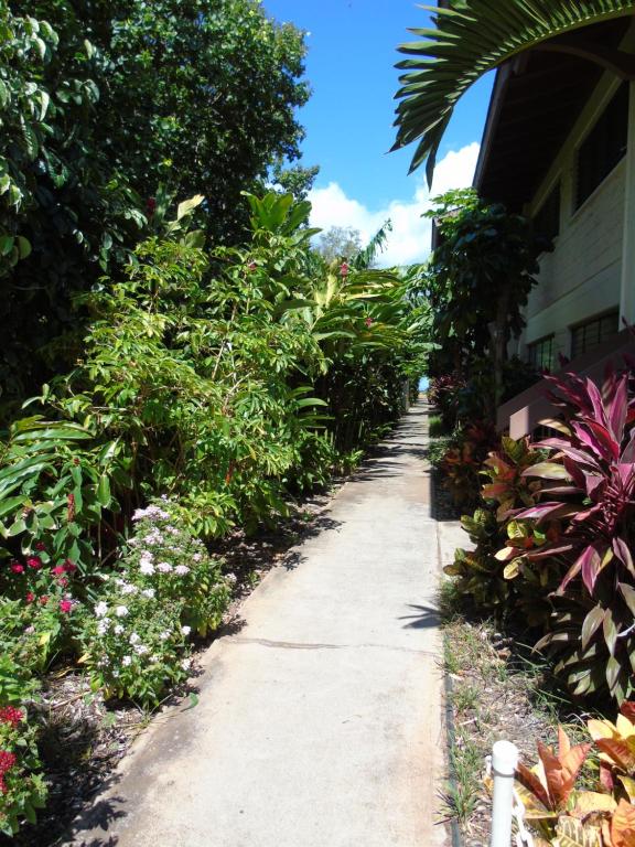 a garden path next to a house with flowers at Aloha KAI - Resort Condo in Kihei