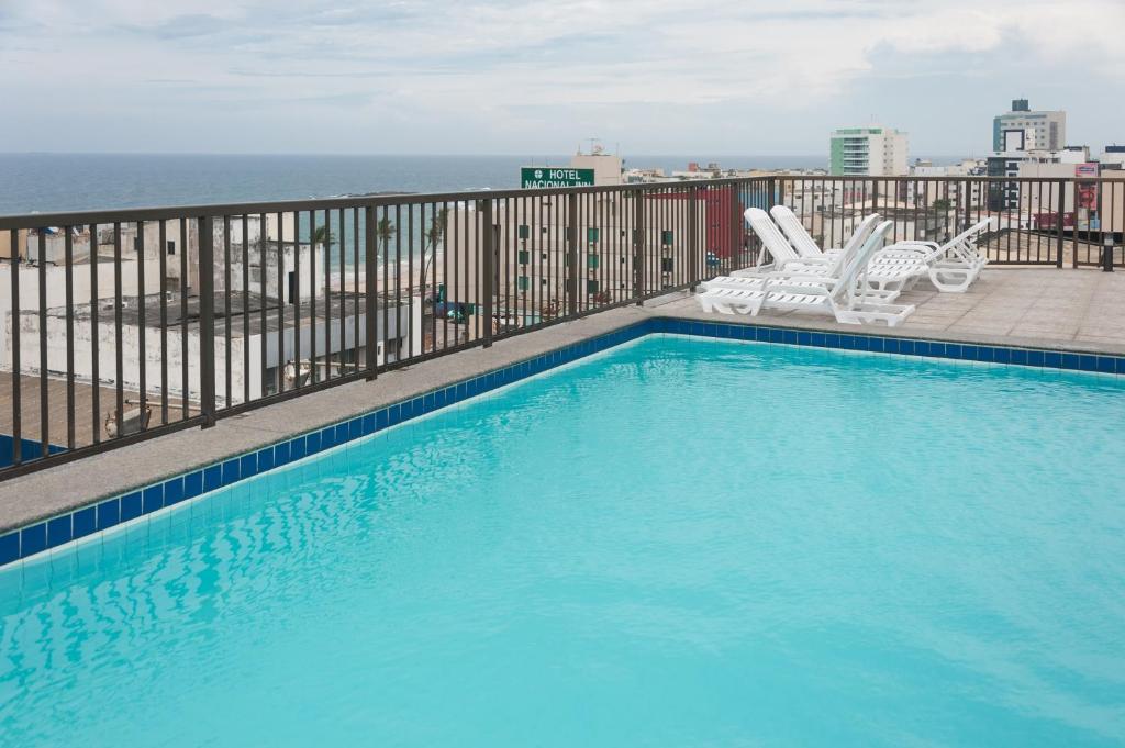 a swimming pool on a balcony with a view of the ocean at Hotel Golden Park Salvador in Salvador