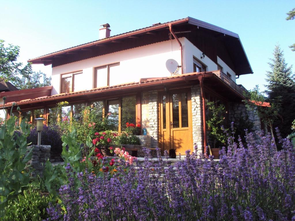 a house with a garden with purple flowers at PLITVICE LAKES KONAK Daic in Jezerce
