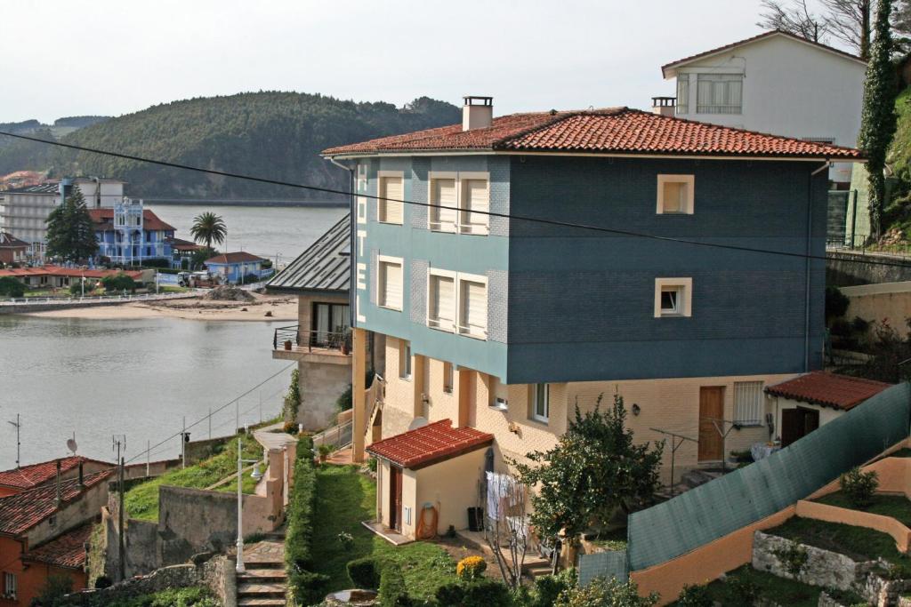 un bâtiment situé sur une colline à côté d'une masse d'eau dans l'établissement Hotel Brisas del Sella, à Ribadesella