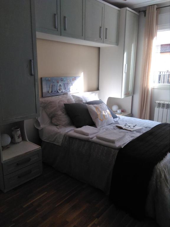 a bedroom with a large bed and a window at Cabañaquinta Senderista in Aller