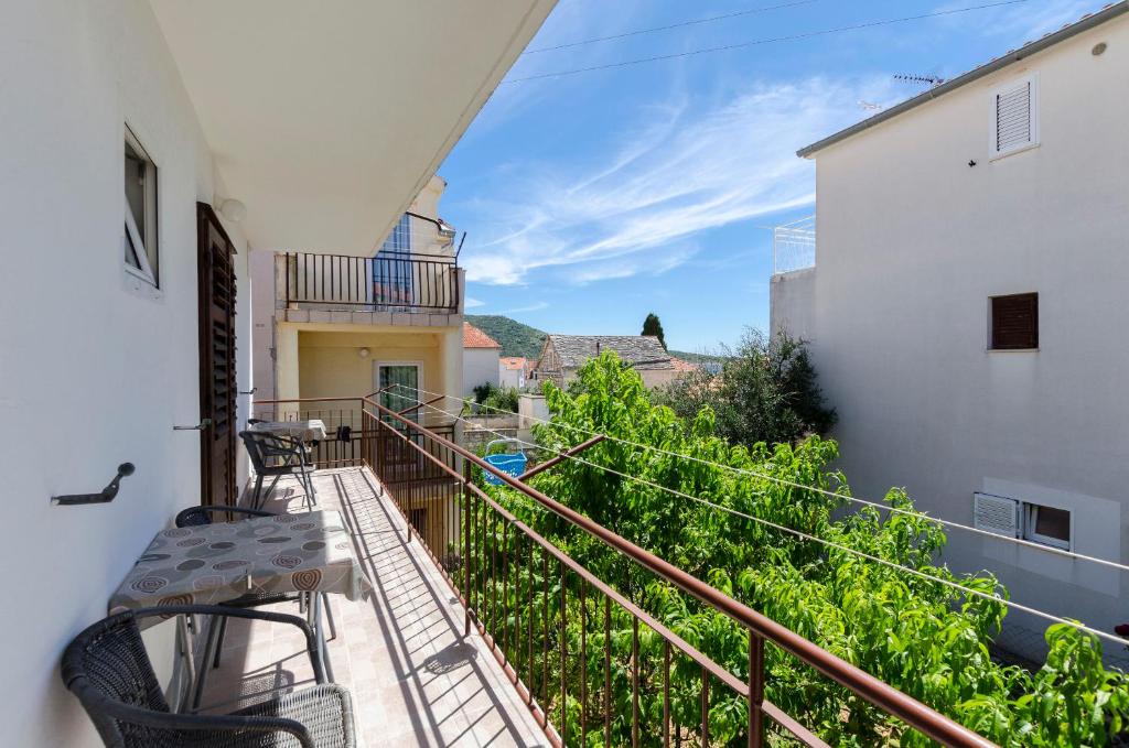 een balkon met stoelen en uitzicht op een gebouw bij Apartments Katica in Primošten