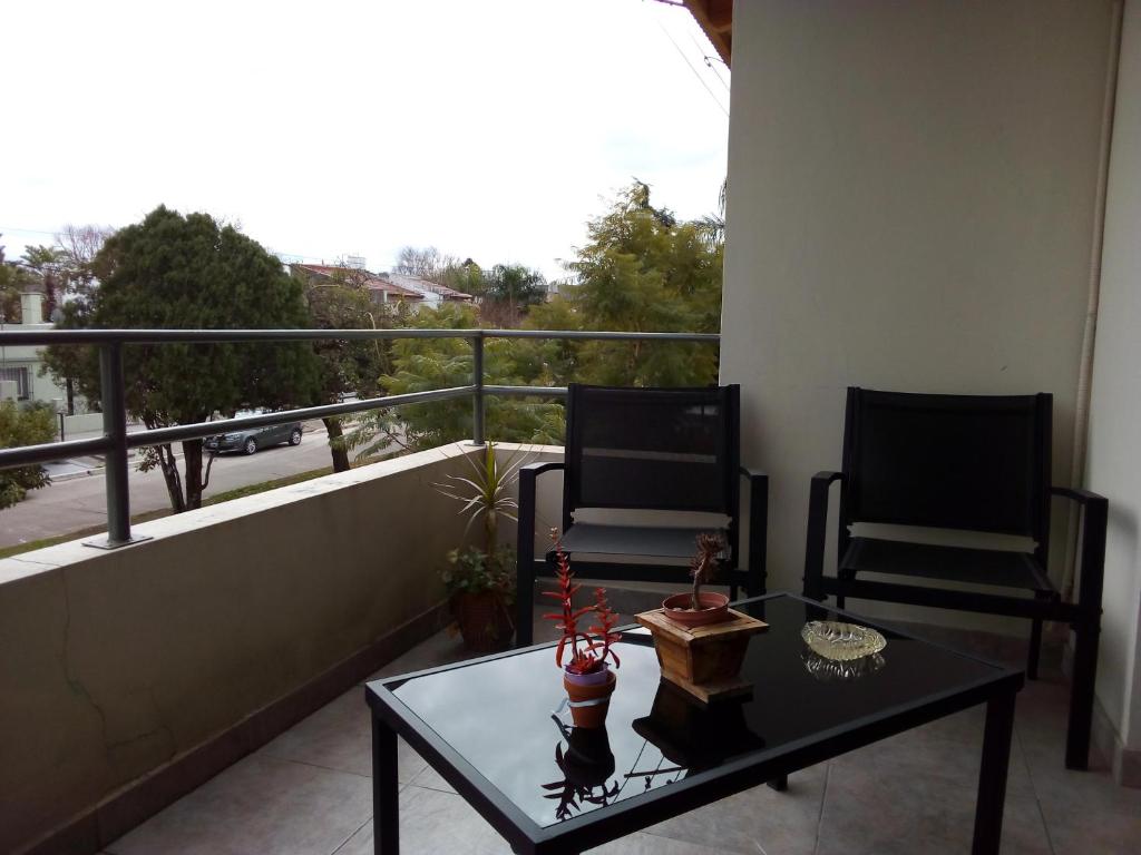 un balcón con 2 sillas y una mesa en el balcón en Departamento Sarmiento ESTELA en San Pedro