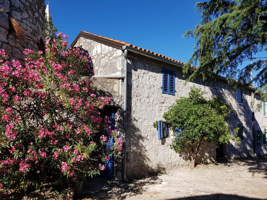 un bâtiment en pierre avec des fleurs roses devant lui dans l'établissement The Istrian, à Vrsar