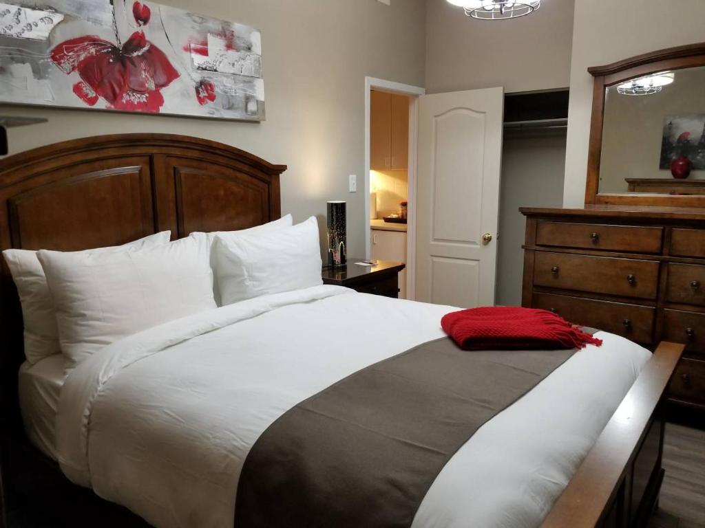 Un dormitorio con una cama grande con una manta roja. en 1-Bedroom Cozy #18 by Amazing Property Rentals, en Gatineau