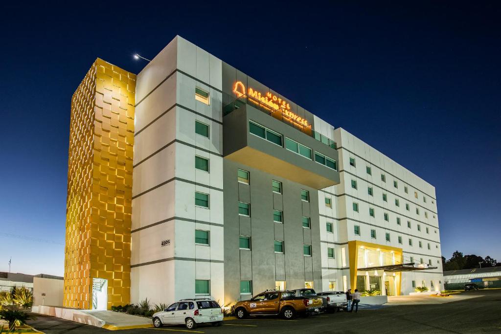 un edificio di un hotel con auto parcheggiate di fronte di Mision Express Durango a Durango
