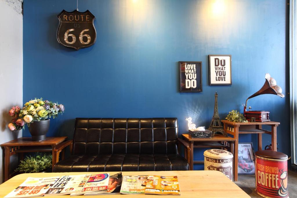 sala de estar con sofá de cuero y pared azul en Tourism Inn, en Yongkang