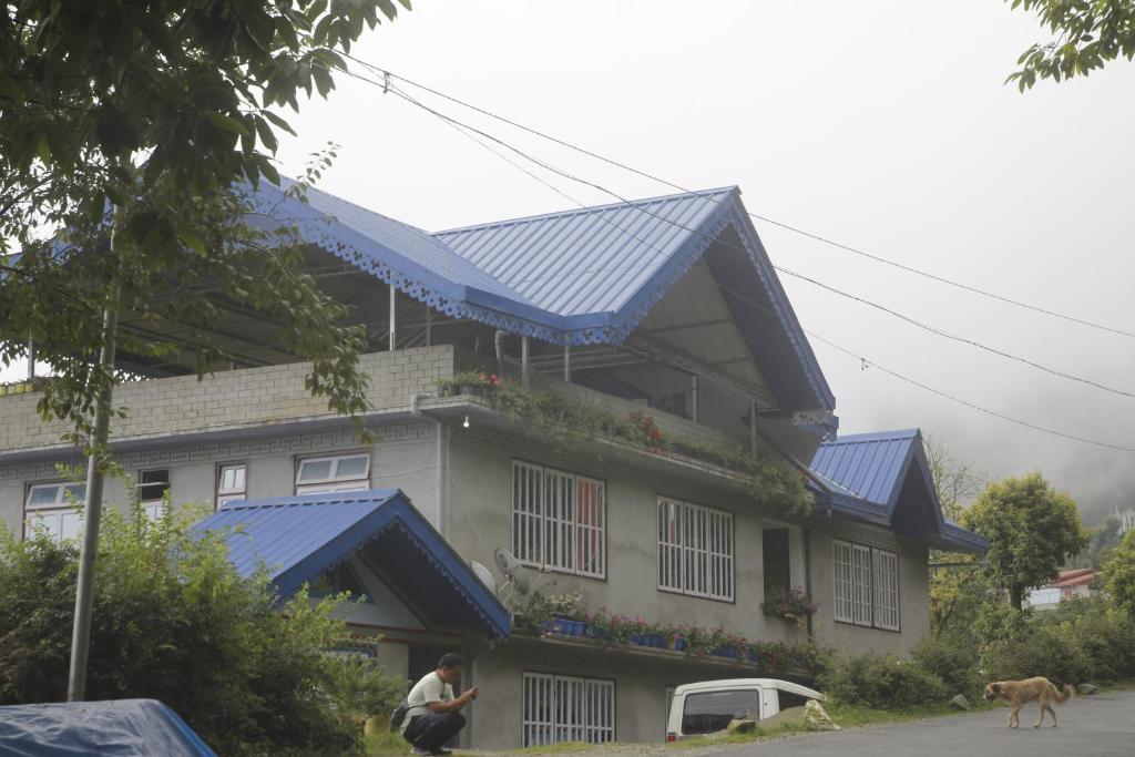 una casa con paneles solares azules en el techo en Vamoose Sherpa Homestay, en Ravangla