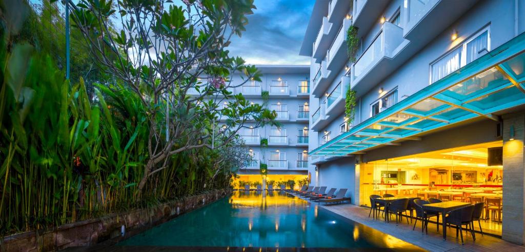 un hotel con una piscina de agua frente a un edificio en HARRIS Hotel Kuta Galleria - Bali, en Kuta