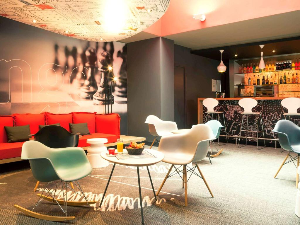 een kamer met een bank, stoelen en een bar bij ibis Lyon Part Dieu Les Halles in Lyon