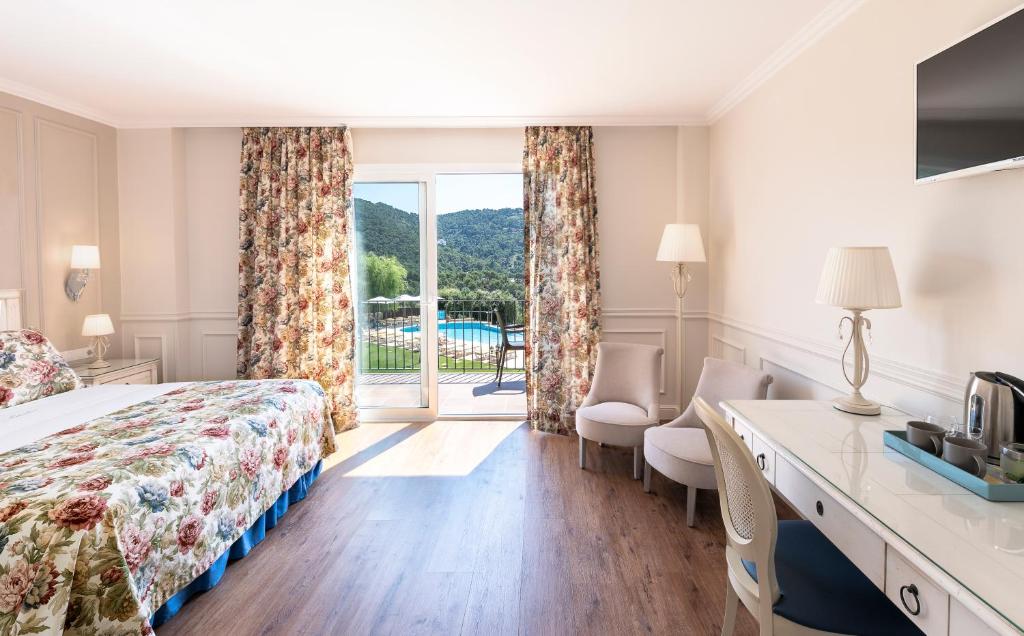 リャフランにあるHotel BlauMar Llafrancのベッド、デスク、窓が備わるホテルルームです。
