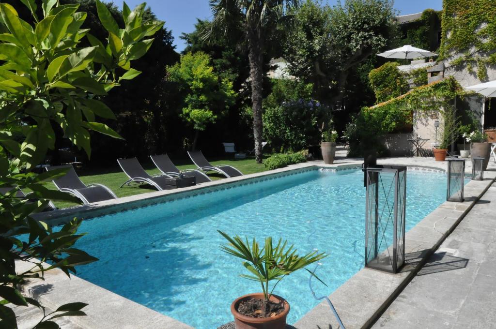 een zwembad met ligstoelen en een resort bij La demeure in Eyguières