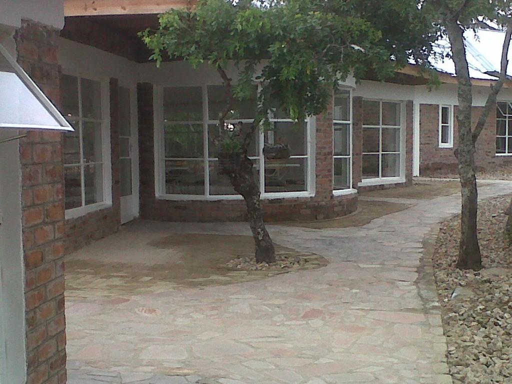 una casa con un árbol delante de ella en Nora Valley Lodge en Ruwa