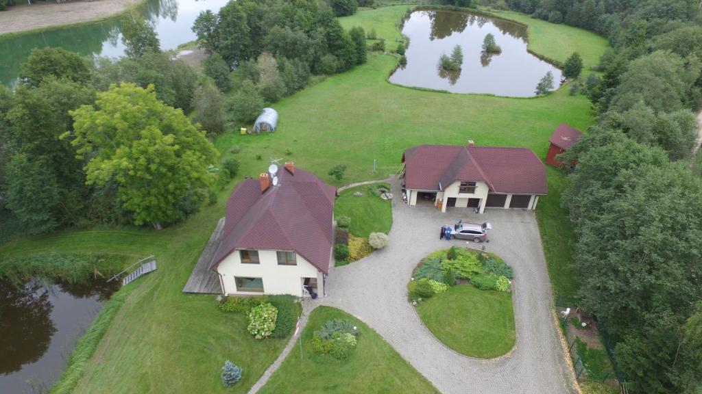 an aerial view of a house with a pond at Roguļi in Cērkste