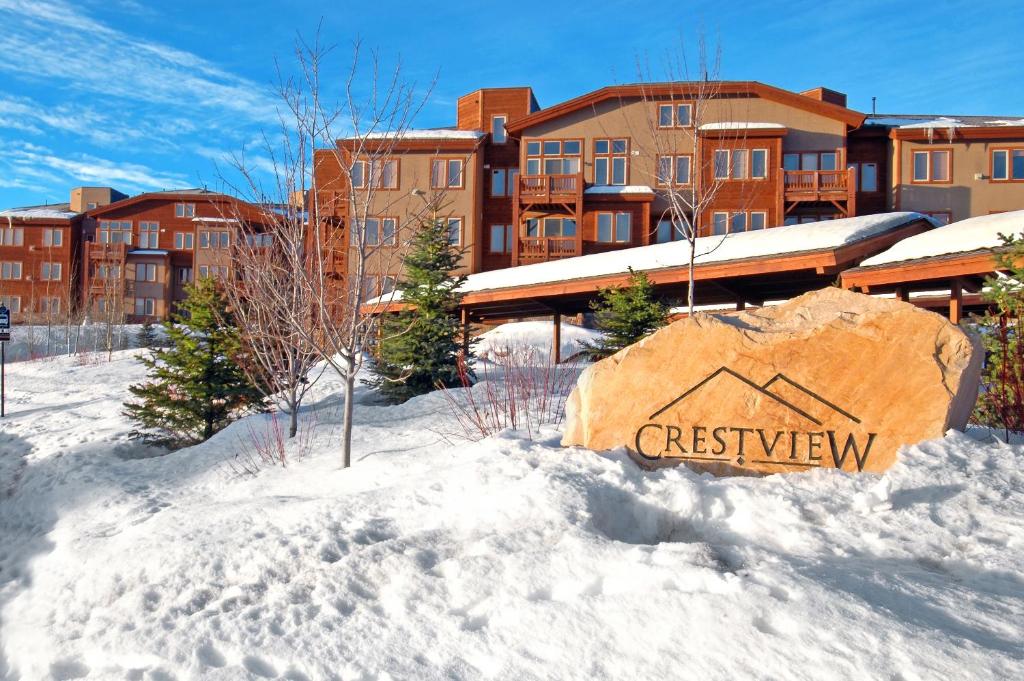 a sign in the snow in front of a building at Crestview Condominiums by All Seasons Resort Lodging in Park City