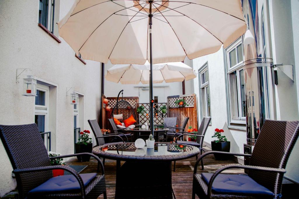 eine Terrasse mit einem Tisch, Stühlen und einem Sonnenschirm in der Unterkunft Hotel Engel in Hilders