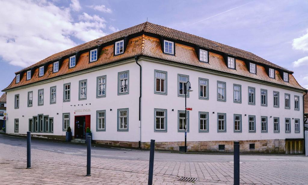 ein großes weißes Gebäude mit braunem Dach in der Unterkunft Hotel Engel in Hilders