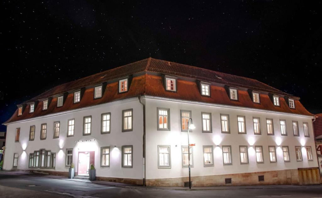 ein großes weißes Gebäude mit nachts eingeschaltetem Licht in der Unterkunft Hotel Engel in Hilders