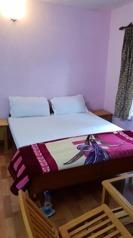 łóżko w pokoju ze stołem i krzesłami w obiekcie Cottage Mini For Backpackers & Small Family w mieście Manāli