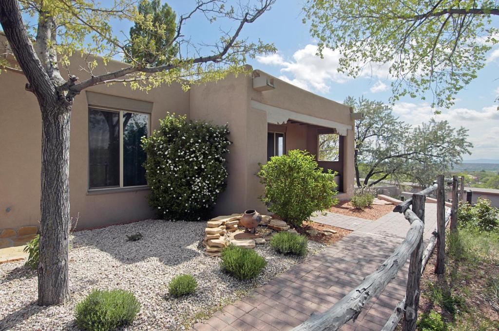 une petite maison avec une clôture devant elle dans l'établissement Fort Marcy Suites, à Santa Fe