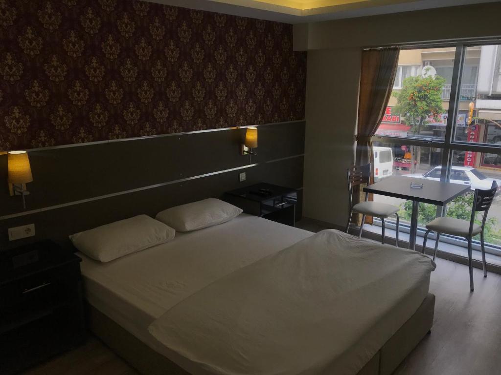 sypialnia z łóżkiem, stołem i oknem w obiekcie Aydın Kent Suit w mieście Aydın