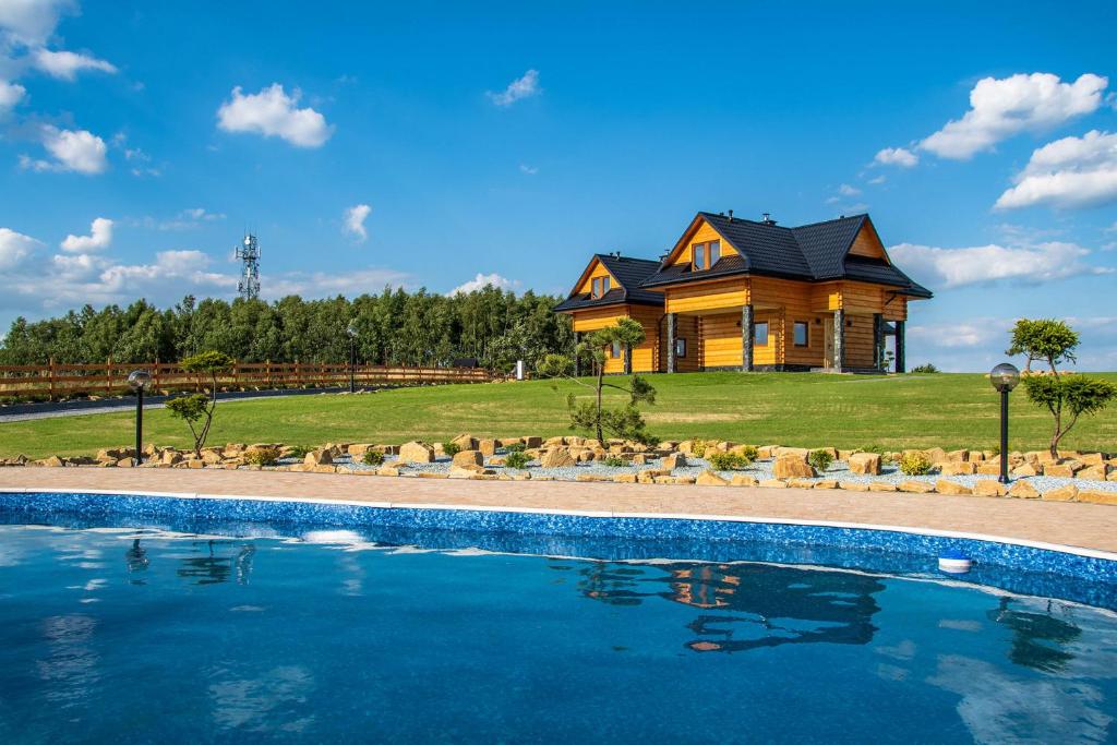 a house with a swimming pool in front of a house at Solankowe Zacisze in Baryczka