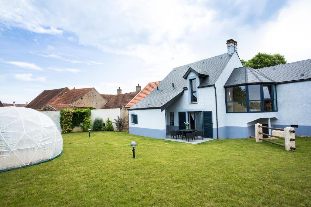 a large white house with a large domed tent in the yard at Maison Indigo in Athie
