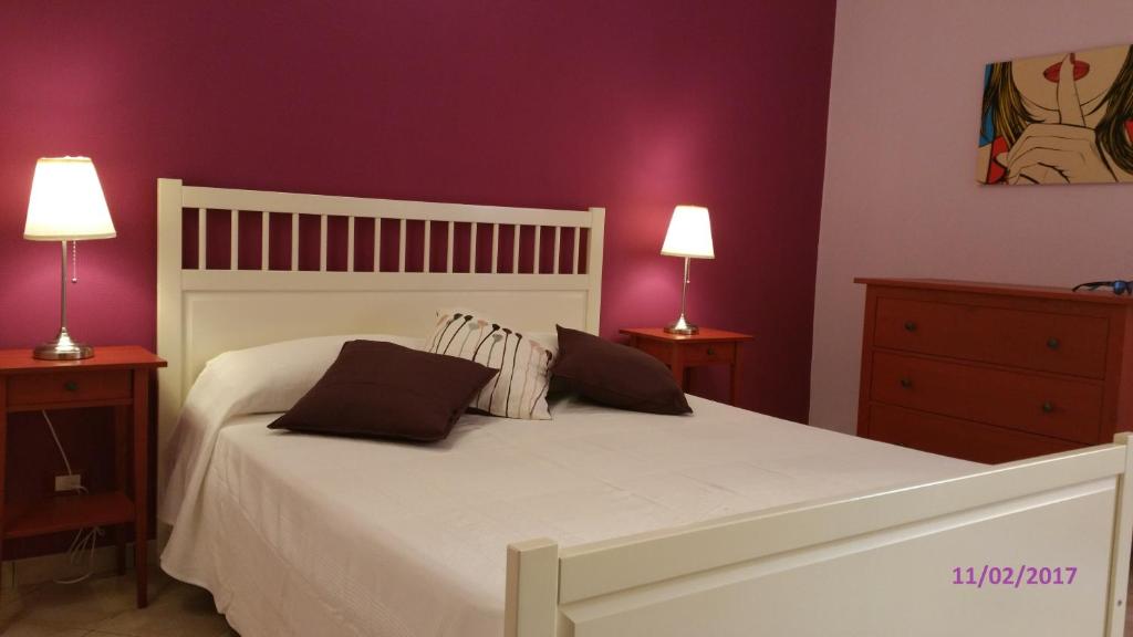 una camera da letto con un letto bianco con due comodini e due lampade di Casa Vacanza Rosa a Pozzallo