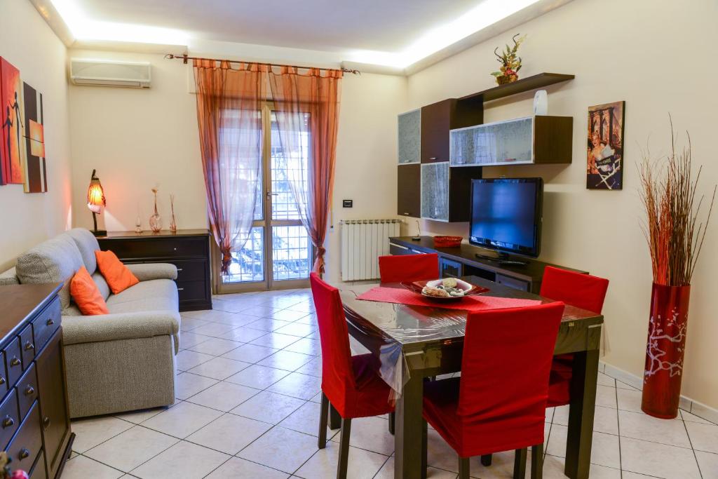 sala de estar con mesa y sillas rojas en Anagnina Home, en Roma