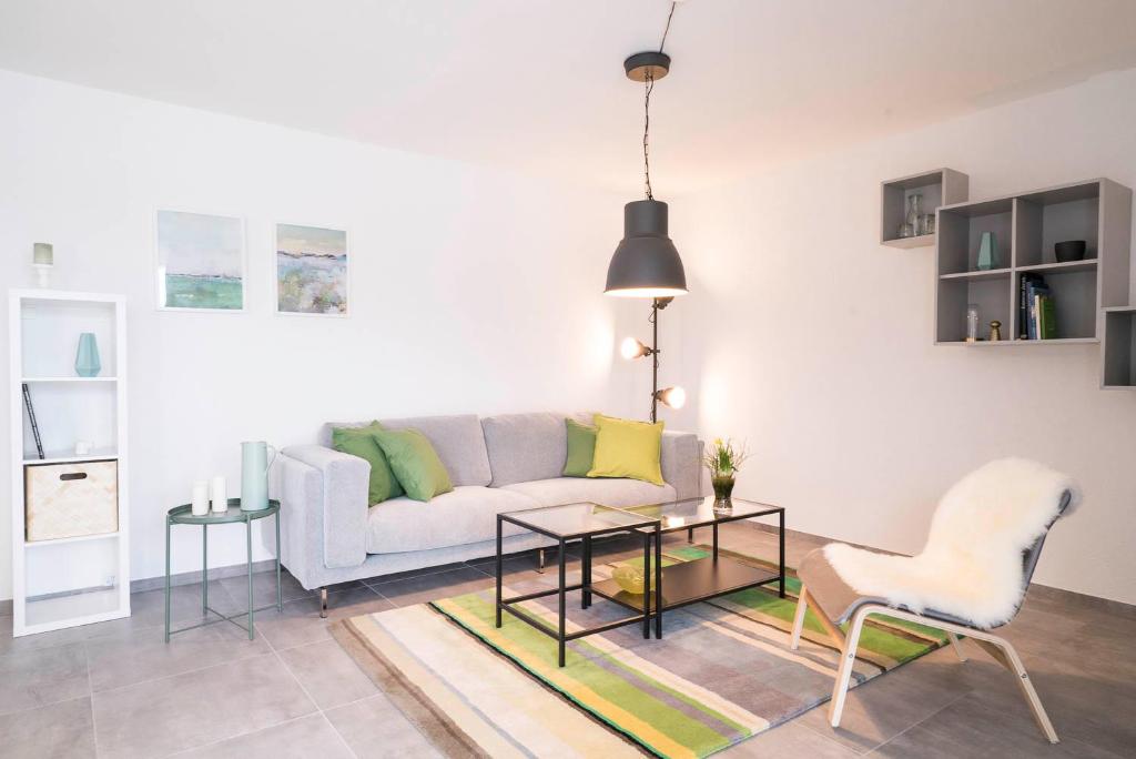 ein Wohnzimmer mit einem Sofa, einem Tisch und Stühlen in der Unterkunft ApartWehr Business&Ferien Apartment Grün in Wehr