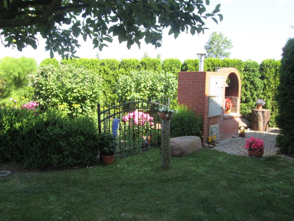 een tuin met een hek en wat struiken en bloemen bij U Jurka in Darłowo