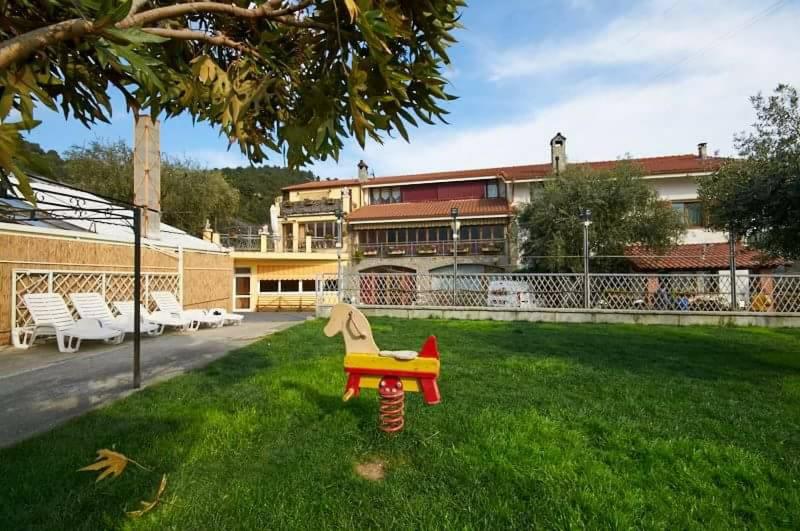 a toy horse sitting in the grass in front of a building at Agriturismo Al Nido Degli Aironi in Sanremo