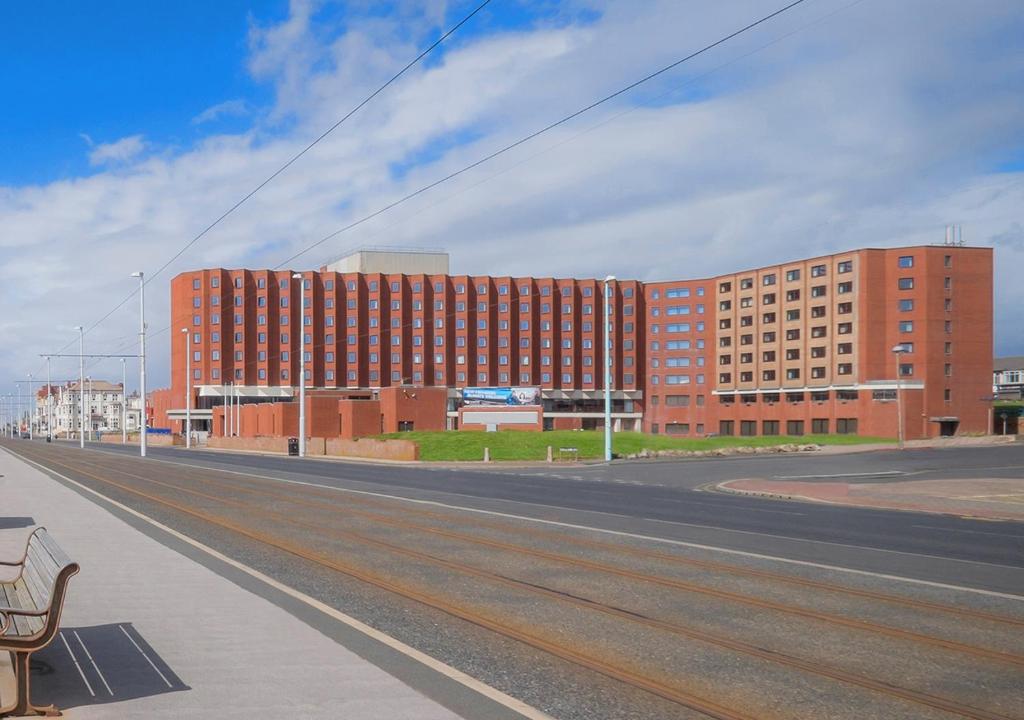 an empty street with a large red brick building at Grand Hotel Blackpool in Blackpool