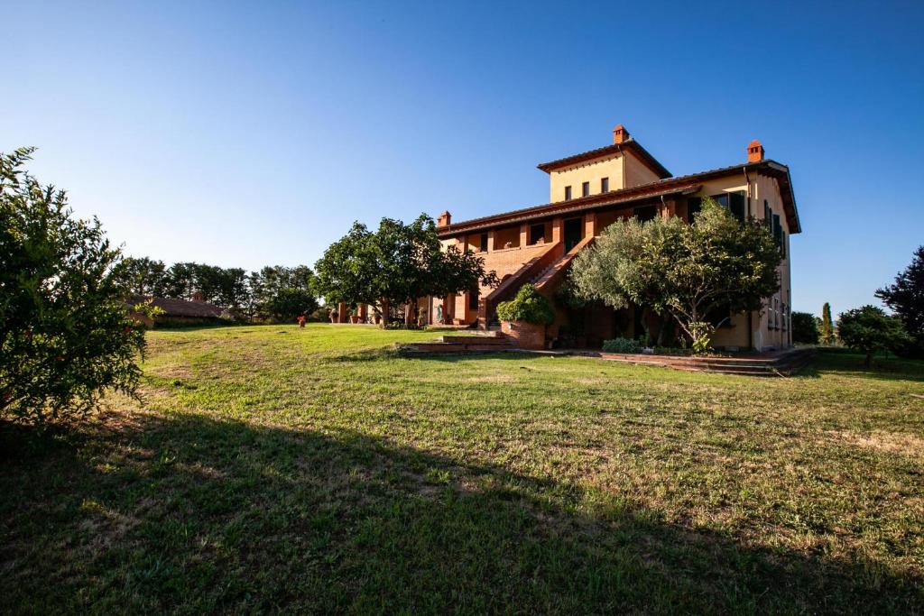 a large house with a grass field in front of it at La Casa in Toscana in Cortona