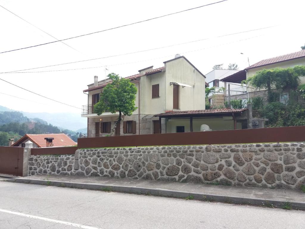 uma parede de pedra em frente a uma casa em Casa Dina Doceira no Gerês