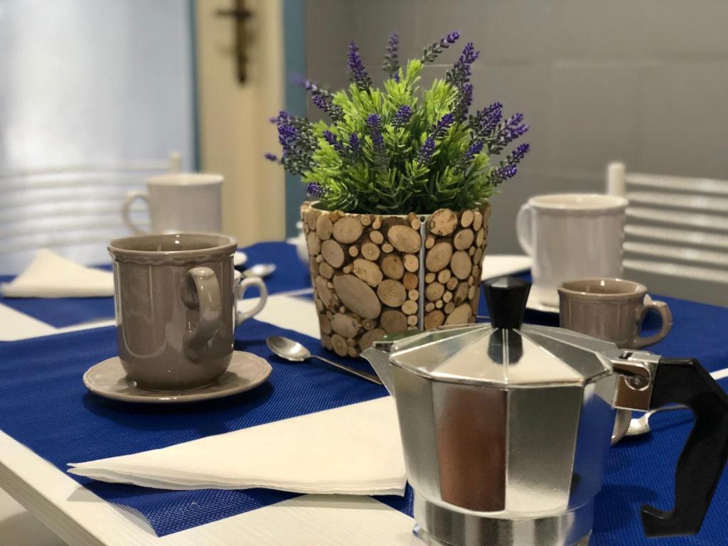 uma mesa com duas xícaras e uma planta com vasos em Casa della nonna Filò em Beverino